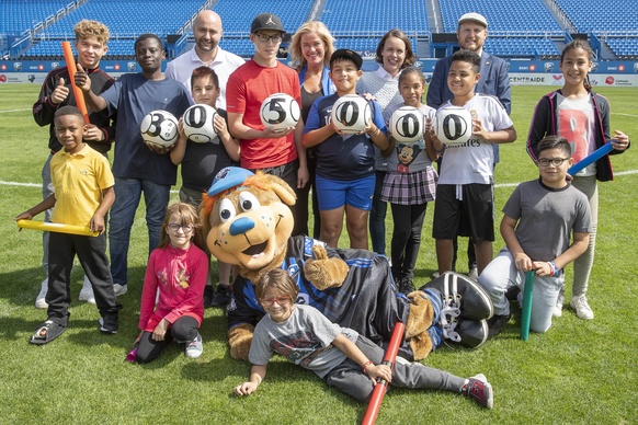 Officiels et enfants qui révèlent le montant amassés à la Coupe Centraide 2019 : 305 000$