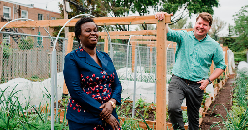 Une dame afro-américaine et un homme devant un jardin communautaire