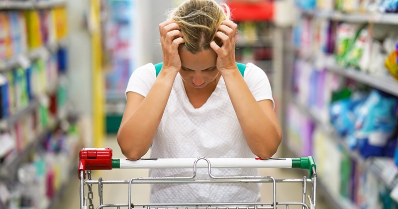 Femme à l'épicerie se tenant la tête